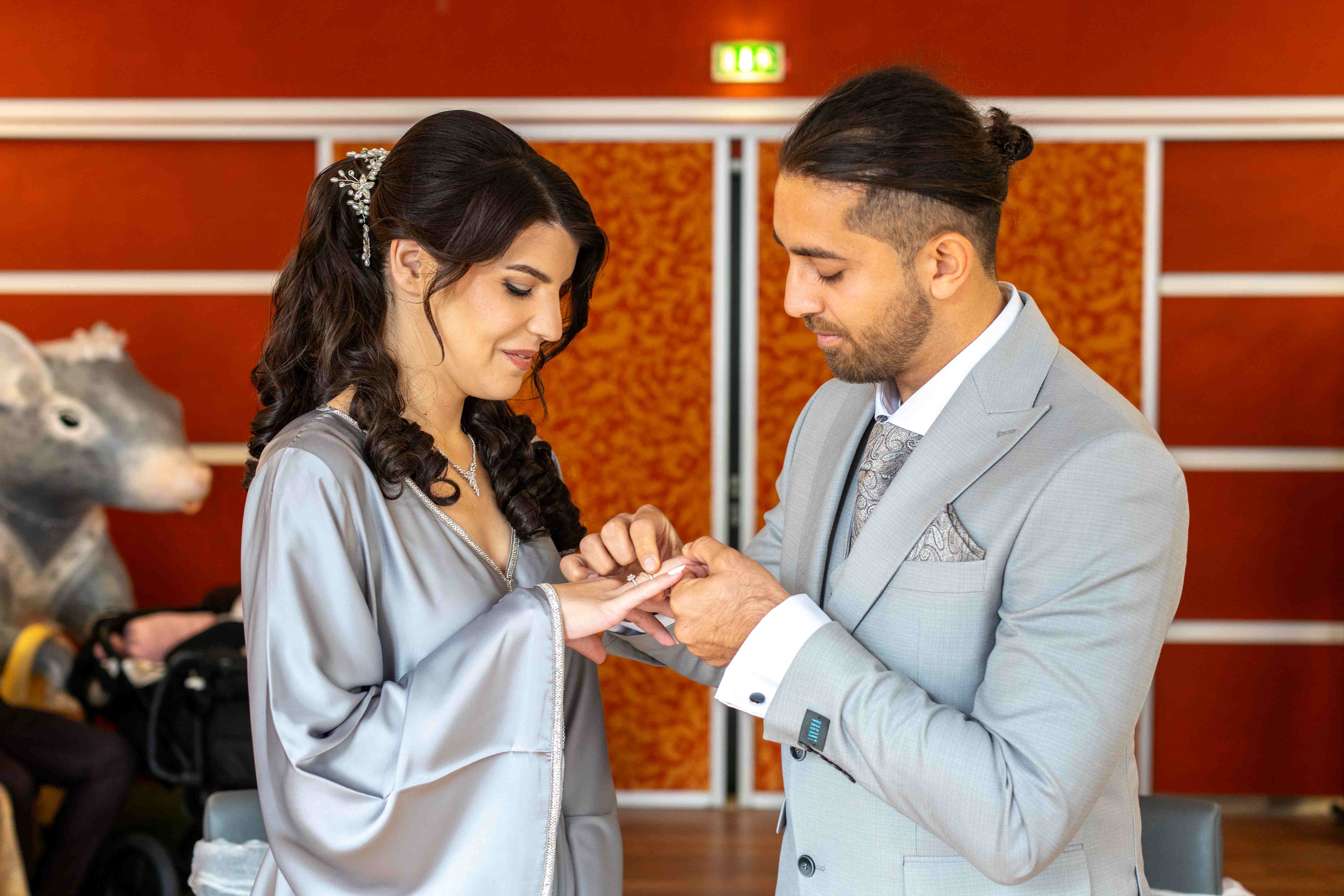Brautpaar steckt sich gegenseitig die Ringe bei der standesamtlichen Trauung an – festgehalten von Hochzeitsfotograf René Laeger in Hameln.